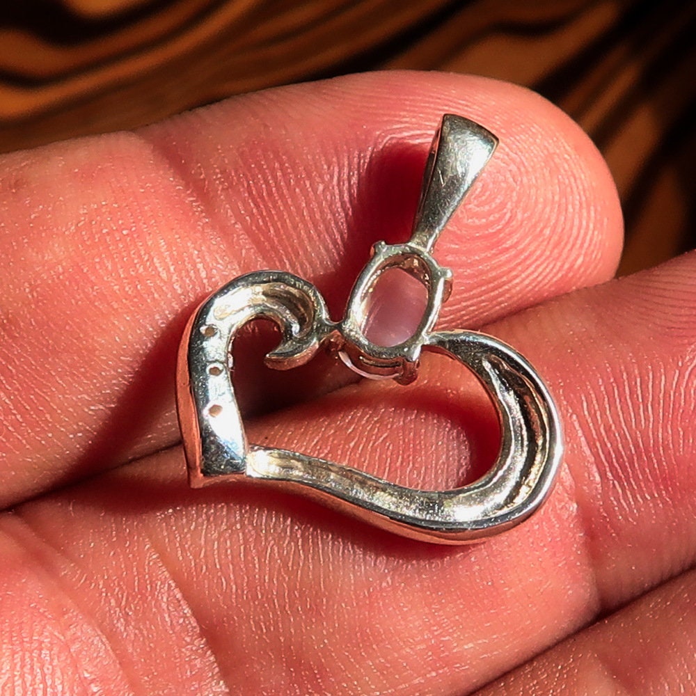 A beautiful Moonstone Pendant set in 925 sterling silver, featuring an oval moonstone surrounded by cubic zirconias, showcasing its elegant heart shape.